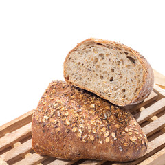 whole grain bread cut in half on wooden cutting board over white
