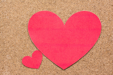 Two red heart-shaped paper on wood background