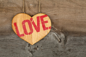 Love Valentines message wooden heart sign on rough grey backgrou