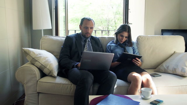 Business couple working on laptop and tablet computer
