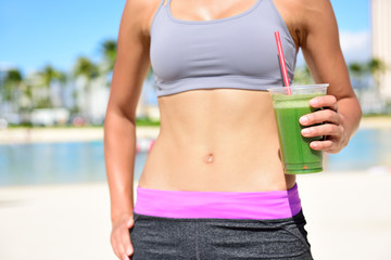 Fitness woman drinking green vegetable smoothie