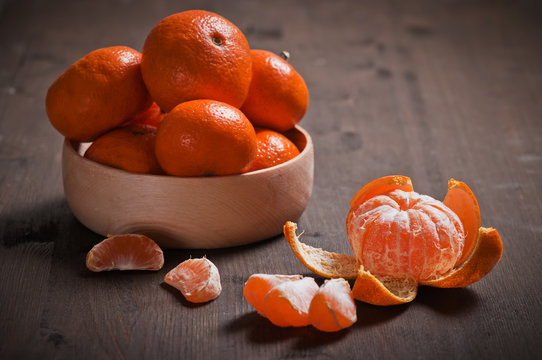 Bowl of fresh tangerines on a wooden background