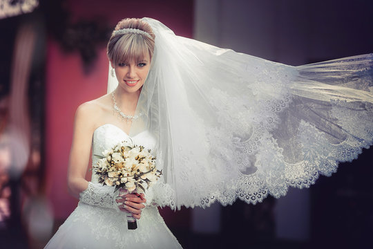Portrait of a beautiful blonde bride with wedding bouquet