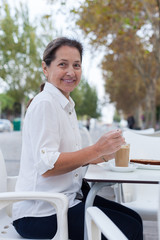 mature woman sitting  in  cafe
