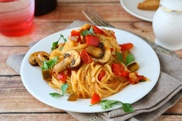 Spaghetti with mushrooms and peppers on a plate