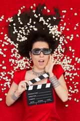 Obraz premium Surprised Girl with 3D Cinema Glasses, Popcorn and Clapboard