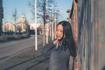 Young beautiful Chinese girl posing in the city streets