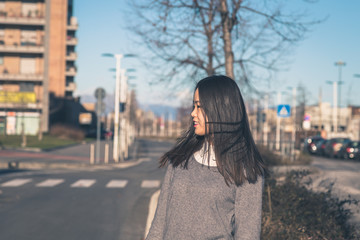 Young beautiful Chinese girl posing in the city streets