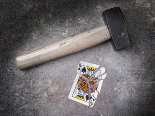 Hammer with a broken card, king of spades