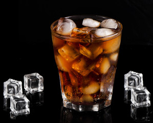 A glass of cola with ice cubes
