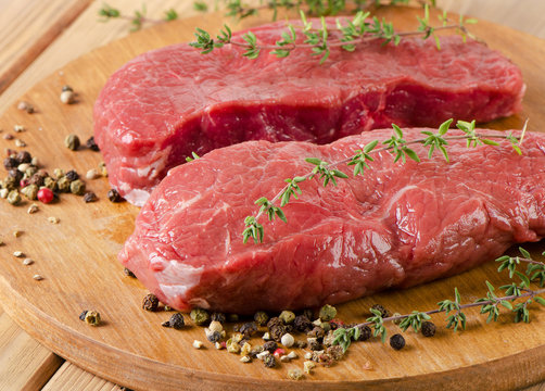 Raw beef  steak on  a  cutting board.