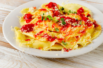 ravioli  with a tomato sauce on wooden table.