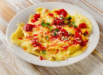 Italian  ravioli  with a tomato sauce on wooden table.