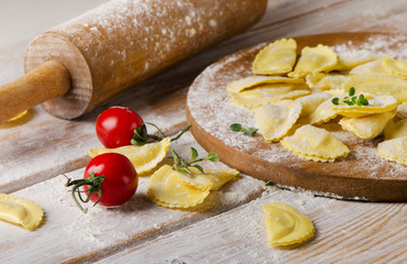Ravioli on with flour  on  wooden backround.