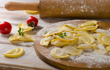 Fresh Ravioli on with flour  on  wooden backround.