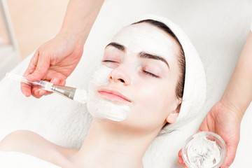 Young woman facial mask applying in beauty parlour