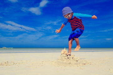 little boy jumping on the beach