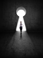 businesswoman against black wall with key hole