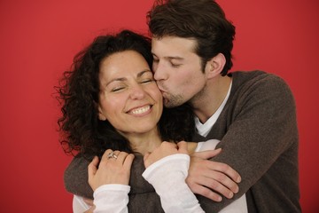 Happy couple on red background in love © mangostock