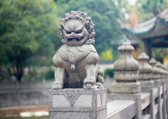 stone lion sculpture on the fence in the park