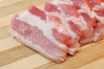 raw bacon on a cutting board