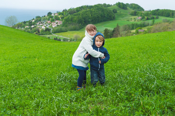 Two adorable kids playing in a field, hiding from coming storm
