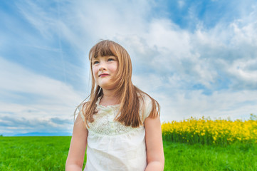 Outdoor portrait of a cute little girl in a countryside