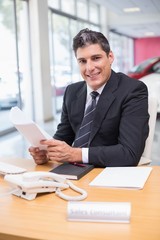 Smiling salesperson holding a document