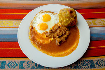 Bolon de verde with fried egg and meat stew ecuadorian food