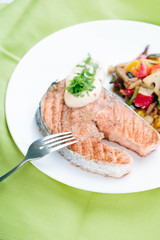 Grilled Salmon with Fresh vegetables on green background
