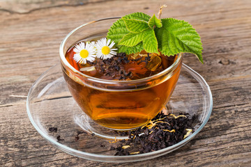 Glass Cup Tea with and Mint Leaf, on brown wooden palette