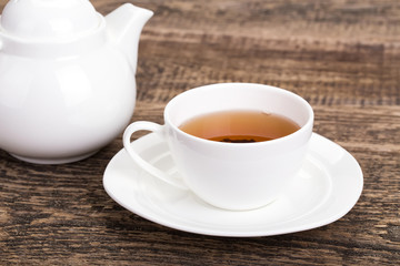 Image of ivory tea cup and kettle on wooden palette