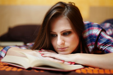 Woman reading a book on the bed