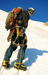 Alpine climber balances on the ice snowfield