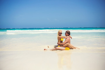Cute couple resting on the shores of the azure sea