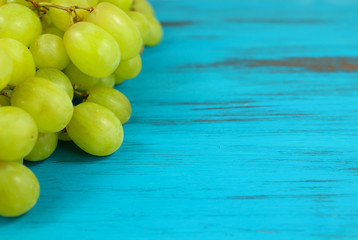 Bright green grapes on a turquoise distressed wood background