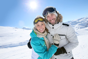 Fototapeta na wymiar Cheerful couple having fun at top of ski slope