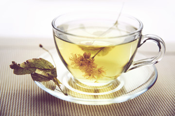 Glass Cup with Linden tea on the table