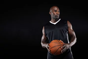 Fotobehang Muscular basketball player on black background © Jacob Lund