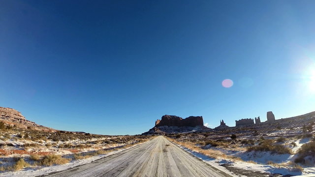 POV road driving sandstone  snow ice covered road blue  Monument Valley Arizona USA