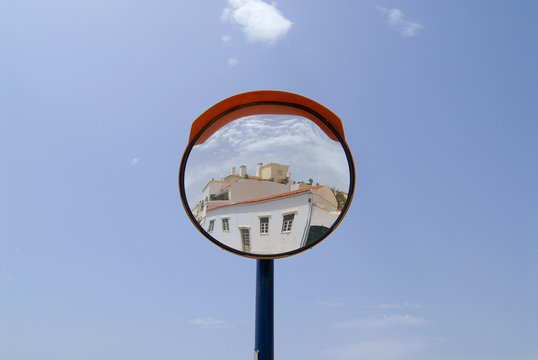 Building reflects in a street mirror in Ferragudo, Portugal.