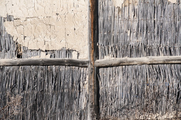 Wall of rural ramshackle barn of reed and clay as background