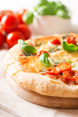 italian pizza on tablecloth with tomatoes close up