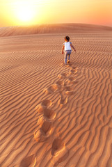 Baby - girl running in the desert.
