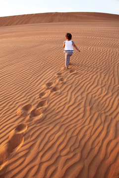 Baby - girl running in the desert.