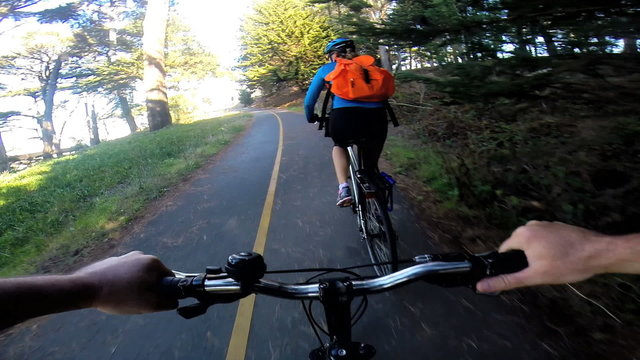 POV bike riding woodland couple exercising lifestyle activity, USA