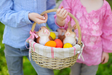 Fototapeta na wymiar Two little girls holding a basket of Easter eggs