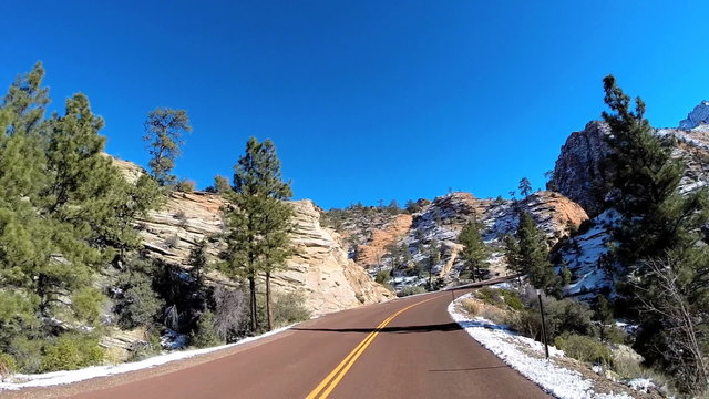 POV road trip driving rocky desert landscape vehicle snow Zion National Park Utah USA