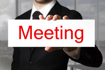 businessman in office holding sign meeting
