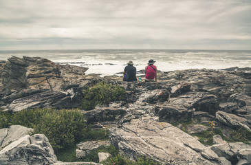 Couple sitting on rock along the wild coast of Tsitsikamma Natio